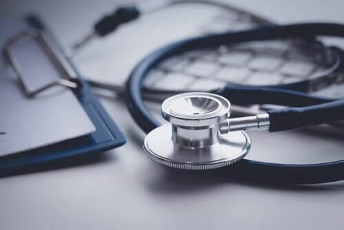 blue stethoscope on desk with medical notes in background