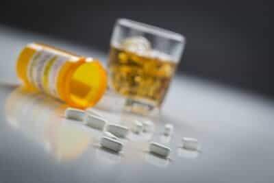 Save Download Preview Several Prescription Drugs Spilled From Fallen Bottle Near Glass of Alcohol