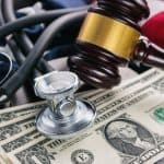 Gavel with stethoscope and money